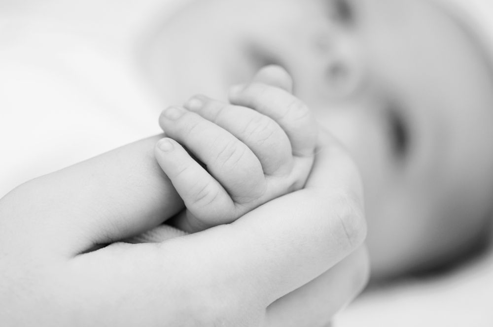 care of infants with CF | Cystic Fibrosis News Today | infant grasping adult's finger