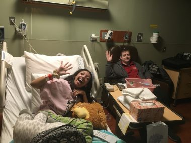 relationships and CF | Cystic Fibrosis News Today | Nicole lies in a hospital bed while Jared sits beside her. They are both smiling and waving to the camera.