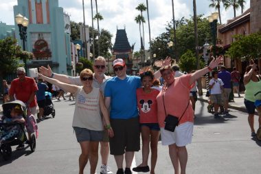 Cystic Fibrosis News Today | Nicole and Jared pose with their parents on a crowded street at Disney World.