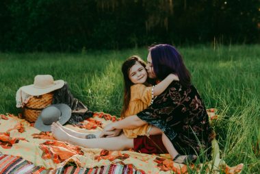 CF and courageous | Cystic Fibrosis News Today | Cheyenne Sowder holds her daughter, Winry, on a picnic blanket spread out in the grass. 