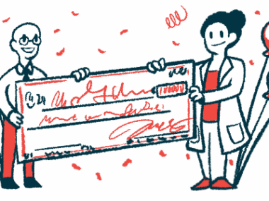 Two people framed by balloons present a giant check.