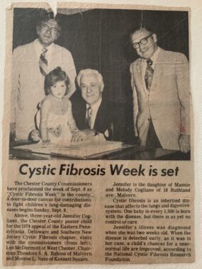 This is a photo of a yellowed newspaper article titled "Cystic Fibrosis Week is set." The picture above it shows three men in suits and ties, one of whom is seated beside a little girl.